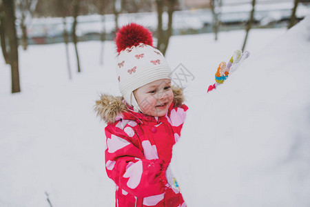 穿着冬天衣着和帽子玩耍的漂亮小女孩图片