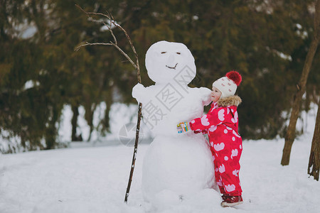 穿着冬天衣服和帽子玩耍的漂亮小女孩图片