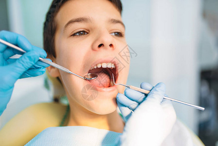 小男孩在牙科柜儿科牙医室里张开嘴的小男孩女图片