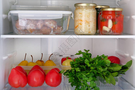 冰箱里的产品健康新鲜食品梨欧芹黄瓜西红柿胡椒保存在冰箱架子上的罐子图片