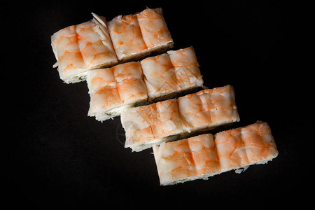 黄瓜奶油乳酪和顶的虎虾在黑背景上供奉图片