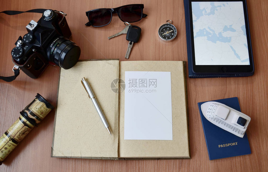 木制背景的笔记本护照眼镜照相机图片