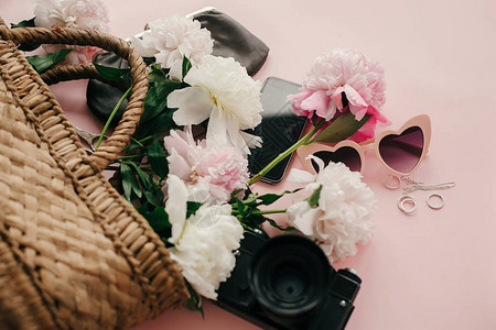 时尚的粉红色牡丹装在草袋手机相机钱包复古太阳镜上背景图片