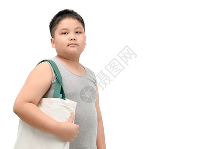 手提袋展开图以白色背景隔离的拖着帆布图袋的胖男孩背景