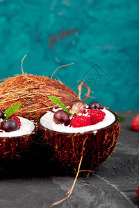 果色沙拉鹅莓椰子贝壳碗中的烤莓背景图片