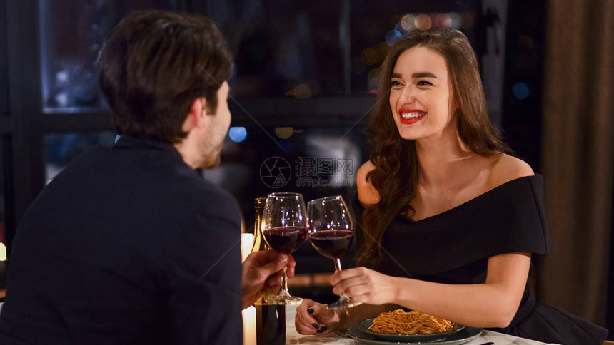 情侣在餐厅吃浪漫晚餐欢乐地一起庆图片