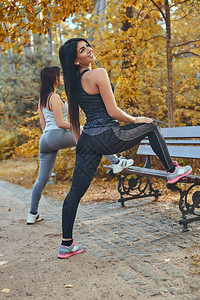 两个健身女孩在秋季公园跑步前享受户外训练图片