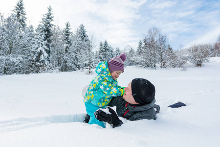 父亲和女儿在新雪中玩耍图片