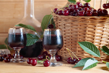 樱桃酒或木本底的葡萄酒和篮子里的图片