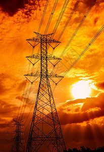 高压电杆和输电线路日落时的电塔电力和能源节能减排配电站带电缆的高压电网塔图片