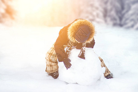 一个孩子雕塑了一个雪人一个男孩在冬图片