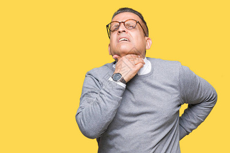 中年商务阿拉伯男子在孤立的背景下戴眼镜触摸颈部疼痛喉咙痛流感图片