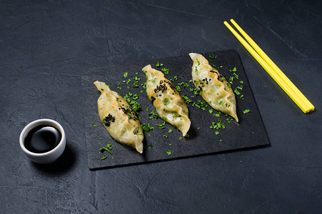 黑石板上的日本烤鸡黄筷子深色背图片