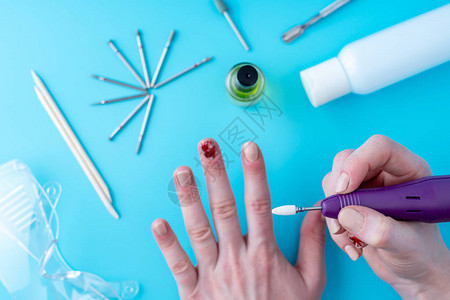 女修造师在工具背景上使用磨剪切割器做专业修指甲硬件的美工图片