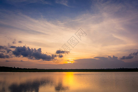湖面风景背上方云层后面的美丽的日落下图片