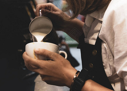 把牛奶倒进咖啡的酒吧咖啡用拿铁做咖图片