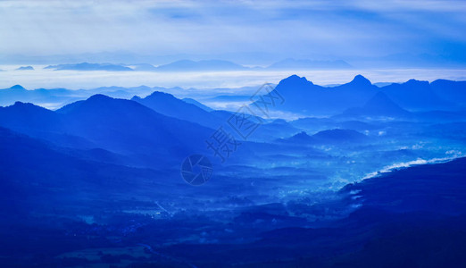 早晨升起的太阳在山上剪影蓝色山脉背景图片