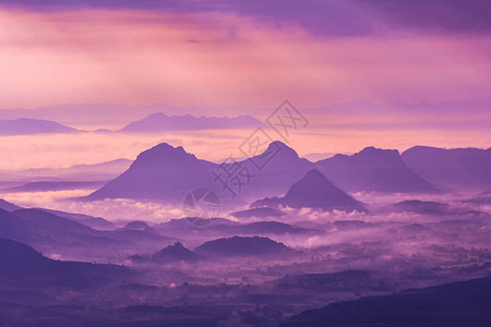 山上有雾紫色天空和升起的风景山背景图片