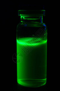 紫外线黑光下的小瓶绿色荧光涂料图片