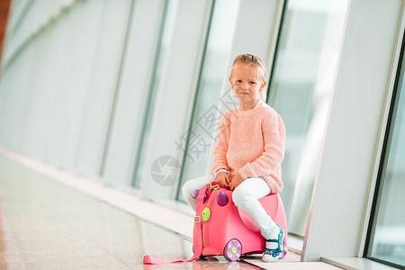 机场可爱的小女孩坐在靠近窗户的大国际机图片