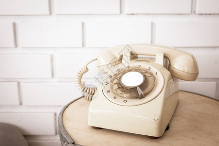 砖墙背景木桌上的老式电话背景图片