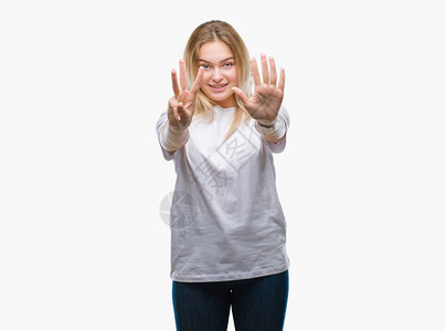 年轻caucasian女人在孤立的背景展示和用第八指头着八指图片