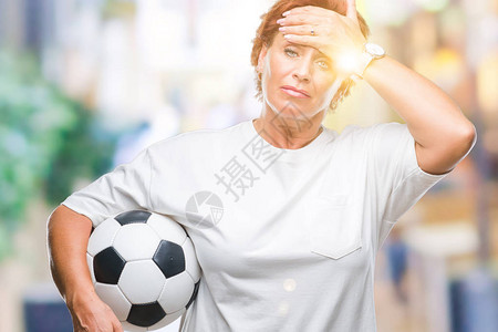 高级caucasian红发女郎在孤立的背景中举着足球图片