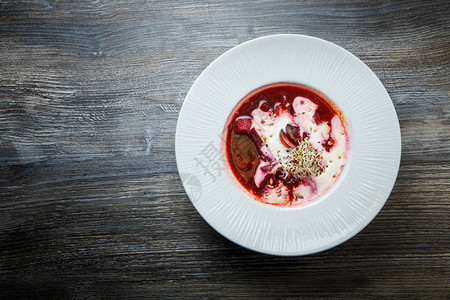 顶视图自制乌克兰罗宋汤装饰着酸奶油和小麦芽在白色餐厅深碗中供应图片