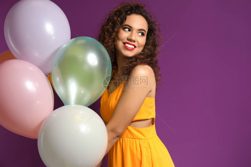 美丽的年轻女子带着气球在彩色背景上图片