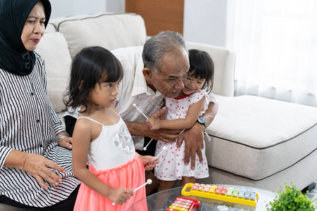 一位祖父母的肖像想听他孙子在客厅一起玩的时候弹图片