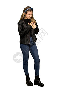 一名穿皮夹克的青少年女孩在孤立的白色背景下心脏疼痛图片