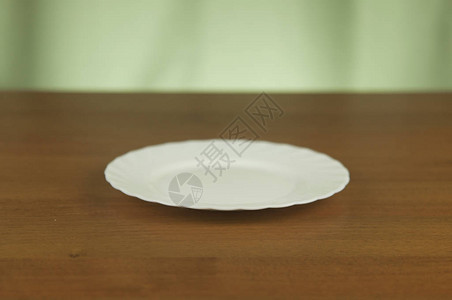 木桌上的白色空盘子图片