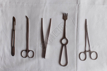 白桌上的外科器械支架钳子刀夹手术刀剪刀图片