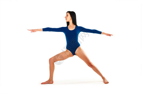 美丽健康的女人在孤立的白色背景上的绿松石身体练习瑜伽瑜伽体式战图片