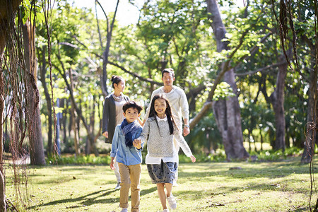 有两个孩子的亚洲家庭在公园中快乐笑容图片