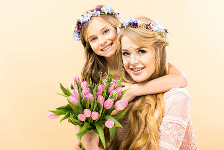 美丽的女人和可爱的女儿拿着一束粉色郁金香图片