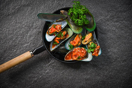 与壳牌鱼绿贝壳一起烹饪的全海产食品板图片