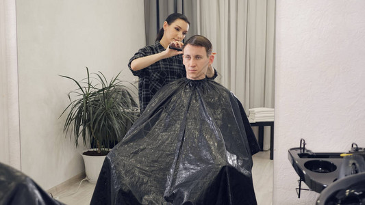 用电动剃须刀理发的男头发修剪器发型的特写专业美发师用图片