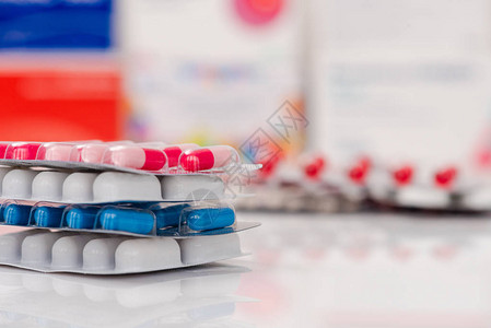白色上的白色蓝色和其他颜色的药丸在塑料包装的药片医疗保健图片