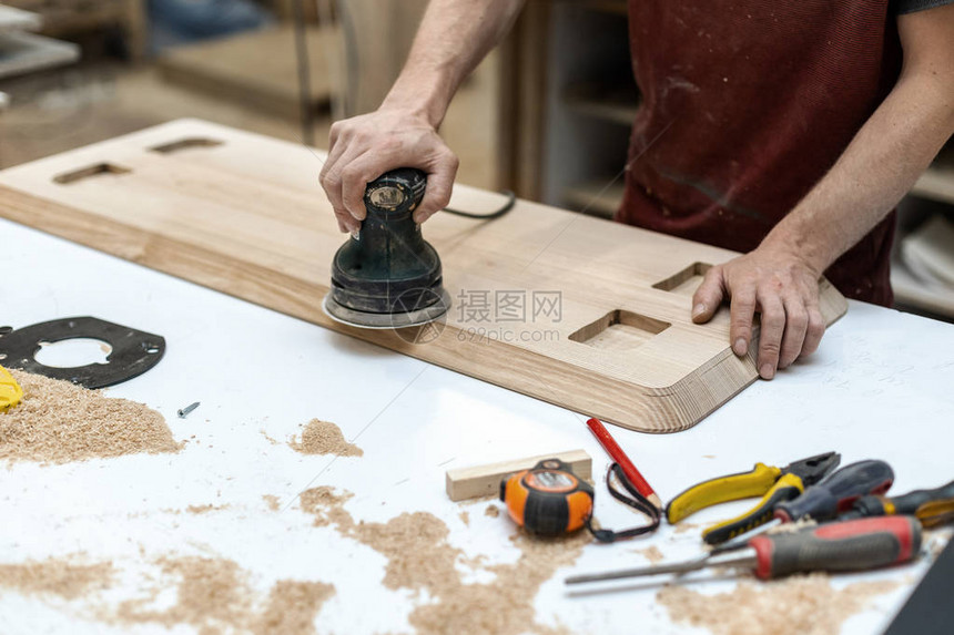 爱好木概念使用特殊电动工具在车库或工作室制作家具的木工杂商图片