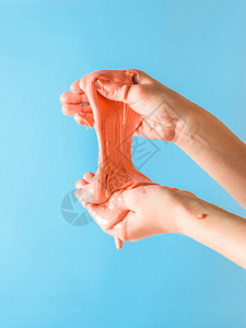 孩子在蓝色背景上伸出双手橙色微笑玩具抗压用于开发手部运图片