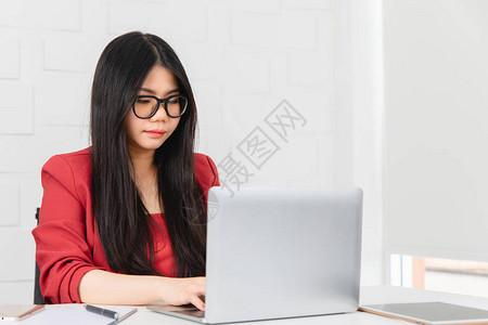 年轻亚洲女商人戴眼镜观光和执着地工作图片