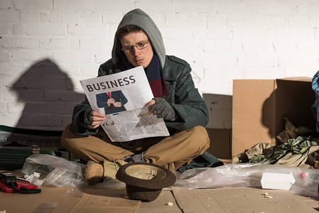 无家可归的乞丐边坐在砖墙边图片