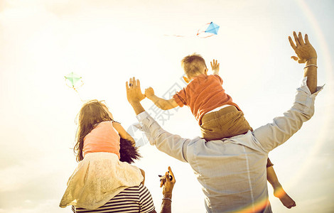 父母和孩子在海滩度假时玩风筝夏日欢乐概念图片