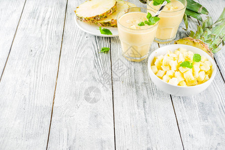 木制桌上有新鲜菠萝切片的自制菠萝冰凉水图片