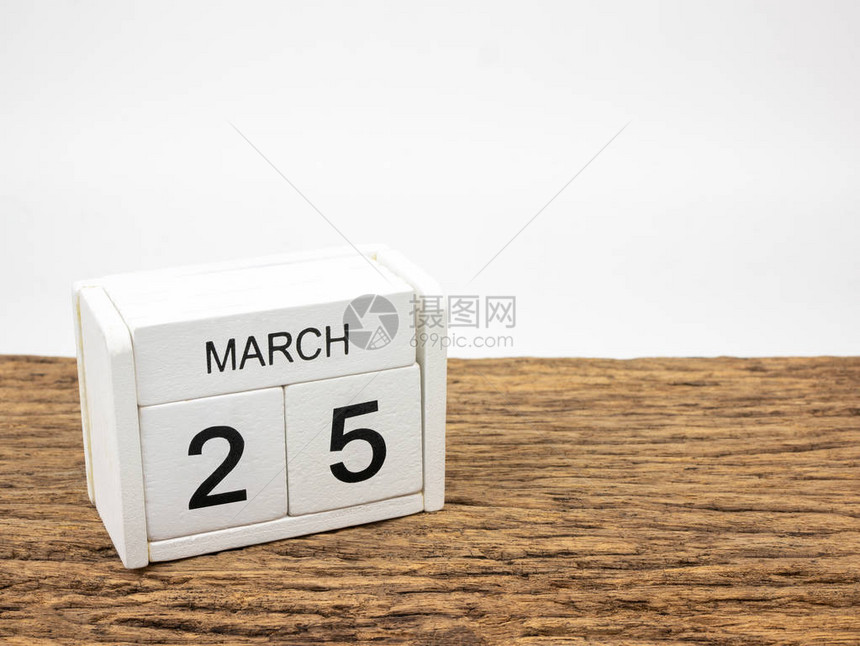 3月25日白色立方体木制日历在老式木材和白色背景与春日图片