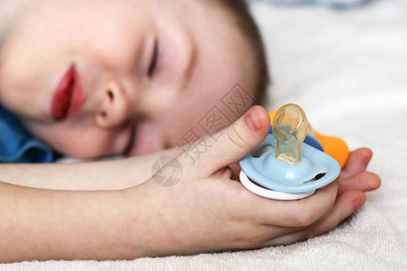 婴儿蓝色奶嘴和婴儿睡觉关闭图片