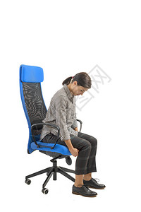 调整办公室内人类工程学椅子的女人图片