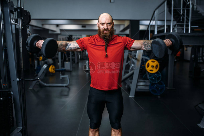 强壮的男举重运动员在健身房用哑铃锻炼图片