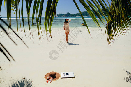 女自由职业者在海滩上旅行通过互联网在笔记本电脑上远程工作旅行时工作图片